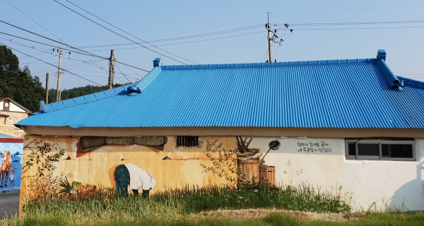 집앞에 있는 파밭과 벽화가 어우러져 마치 벽화 속 어른이 파를 뽑는 듯한 풍경을 만들어 낸다.