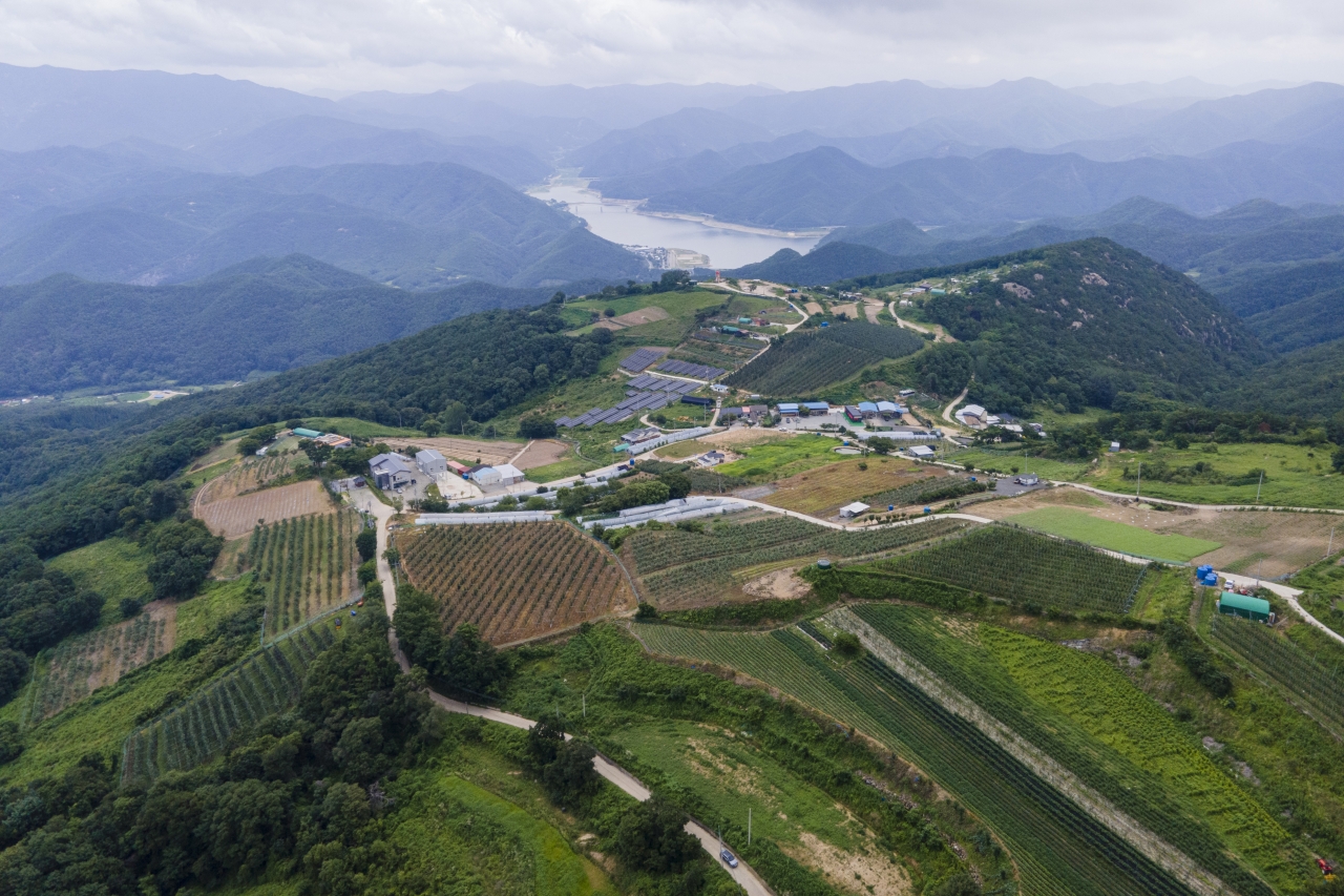 군위 화산마을은 화산(828m) 정상 부분, 고도 7백 미터 부근에 있다. 좁고 긴 꼬부랑길을 오르다 보면 어느 순간 눈앞이 훤해지며 마을이 나타난다. 멀리 군위호가 내려다보이는 풍경이 절경이다.