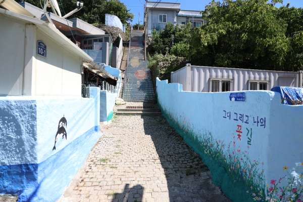 등기산공원으로 오르는 계단은 타일로 꾸며져있고 집 벽에는 아기자기한 벽화가 그려져있다. 중간쯤 '그대 그리고 나' 촬영지도 있다.